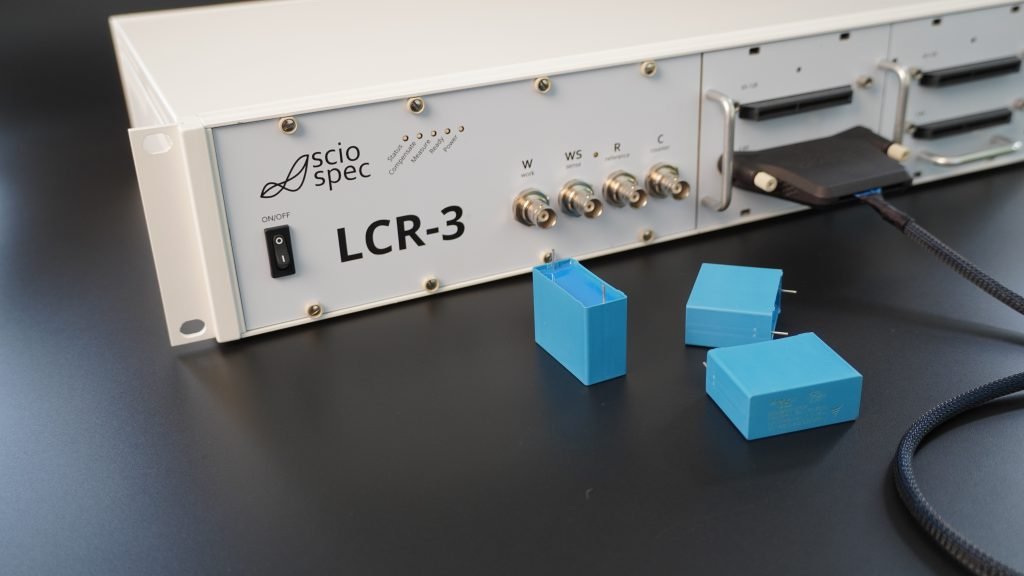 Specification overview of the Sciospec LCR-3 showing frequency range, impedance range, accuracy, and automation features.