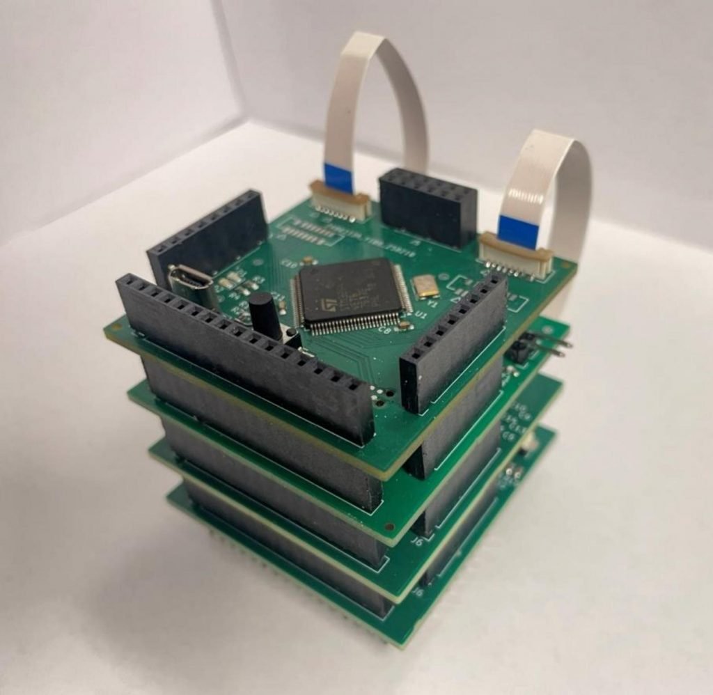 An assembled PCB stack with ribbon cables connected.